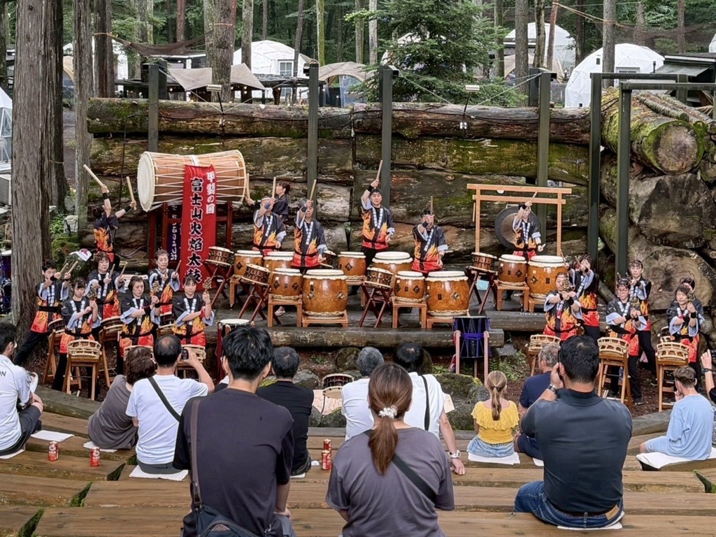 森のステージで太鼓を打つ富士山火焔太鼓の演奏者と観客