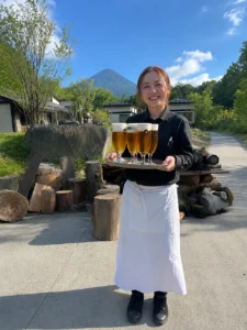 グラスに注がれたビールをもって微笑む女性スタッフ